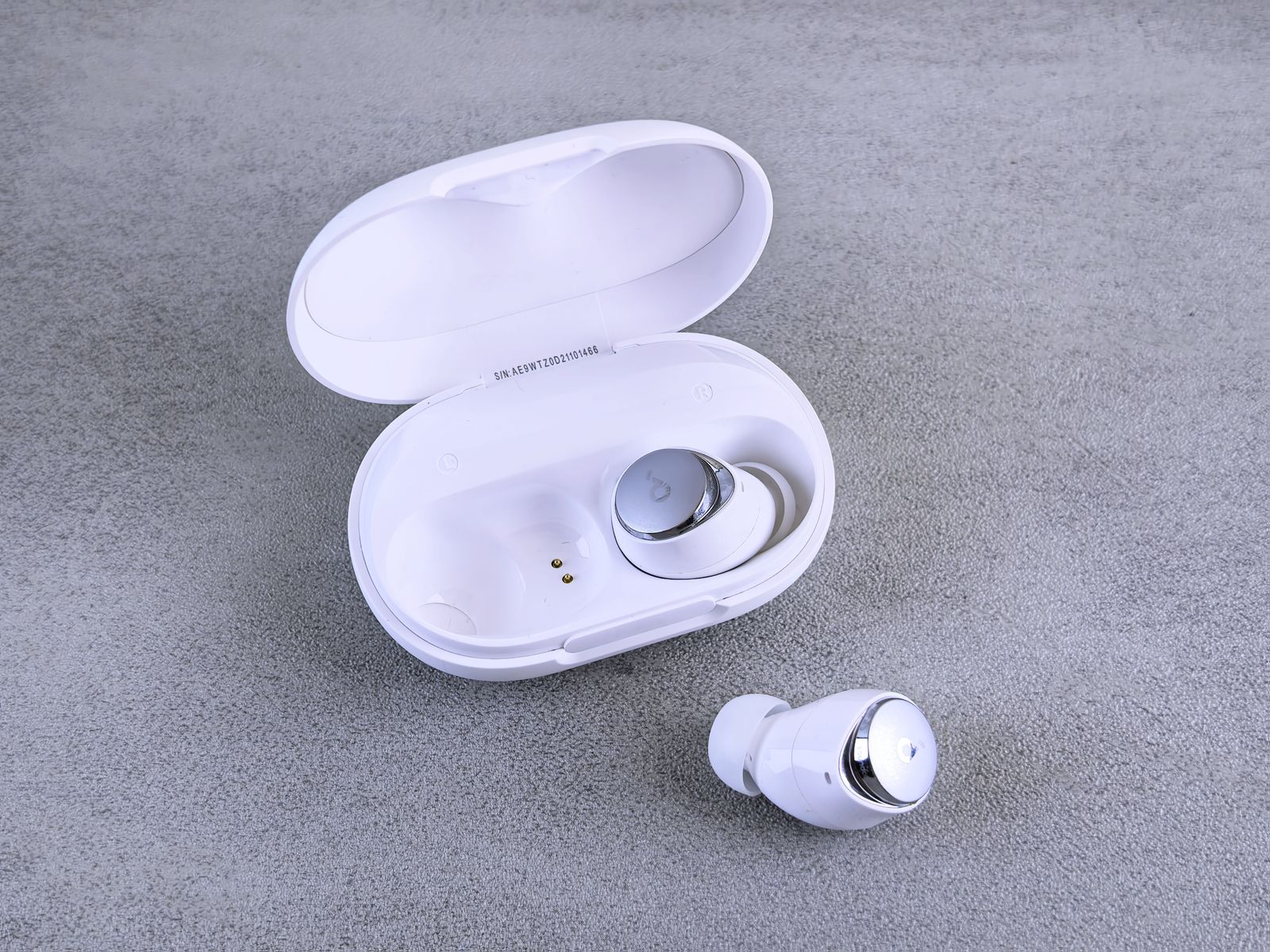 Wireless earbuds with silicone tips beside an open case