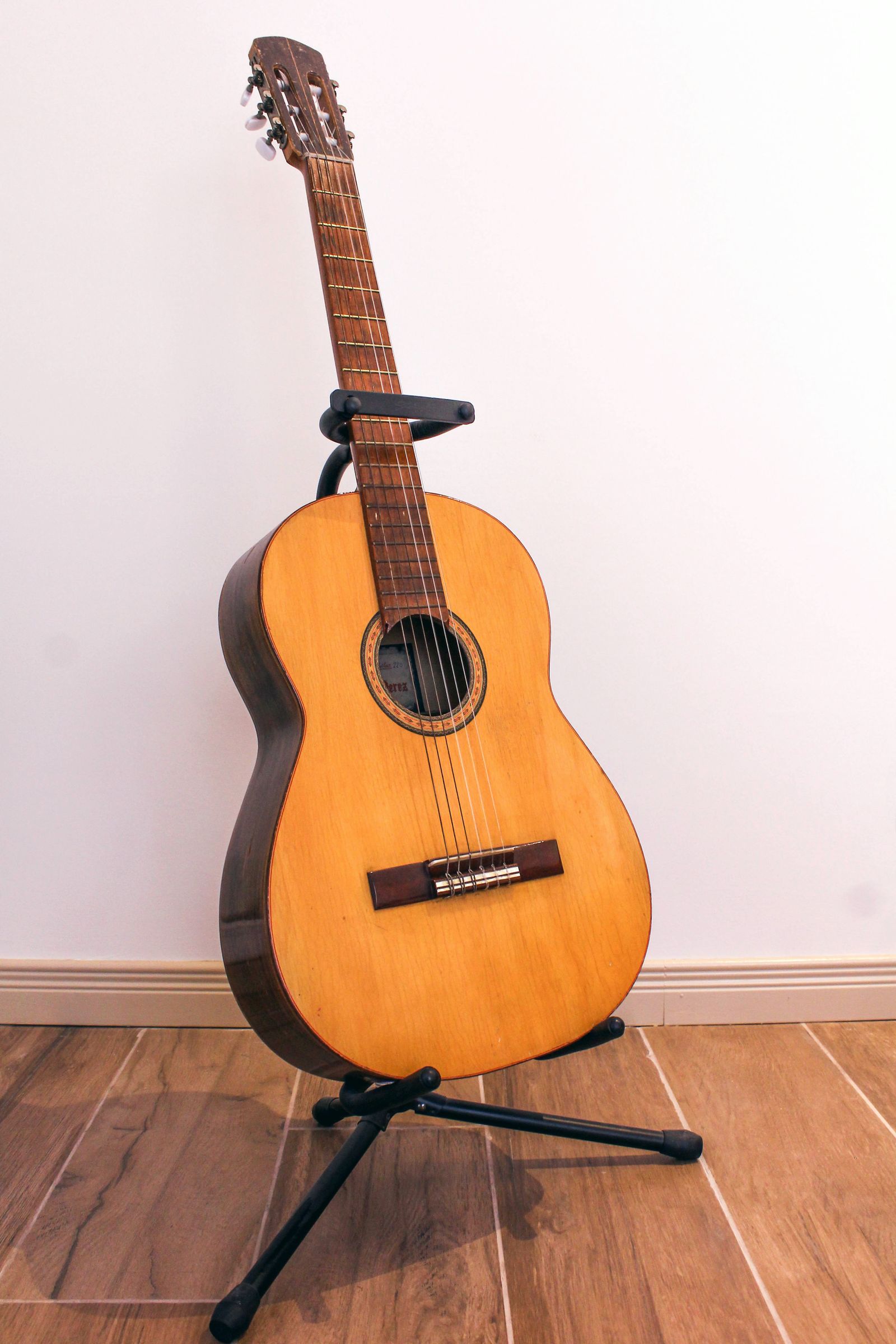 Acoustic guitar resting on a floor stand
