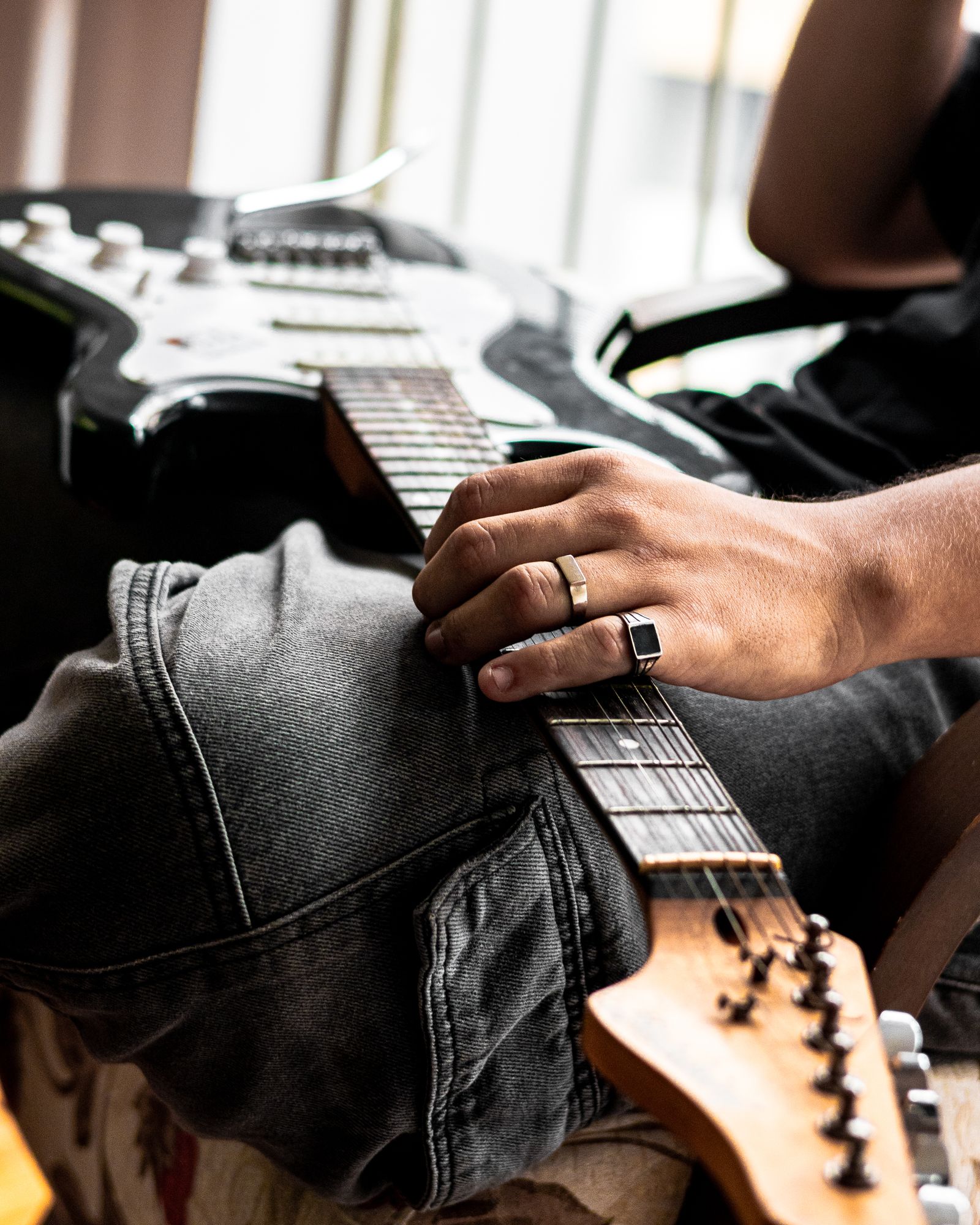 Musician holding an electric guitar across their lap