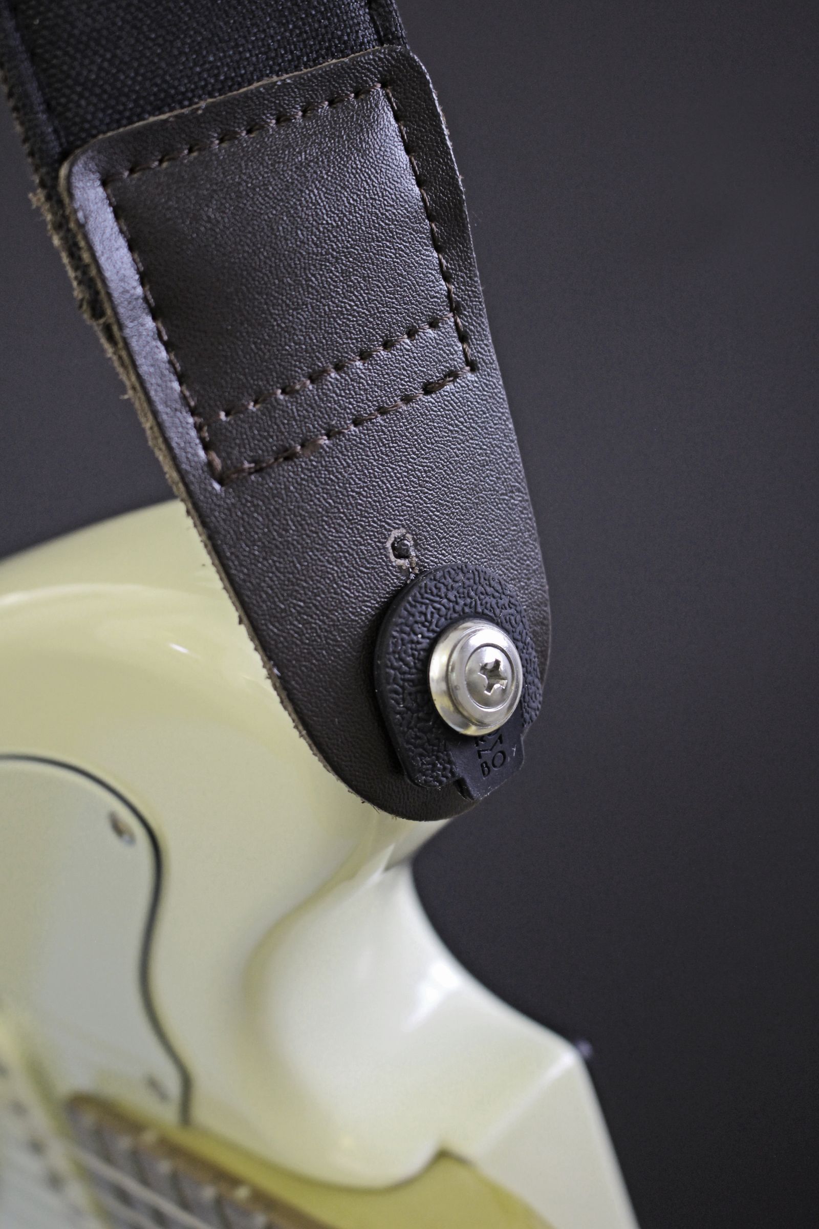 Strap attached to an electric guitar button