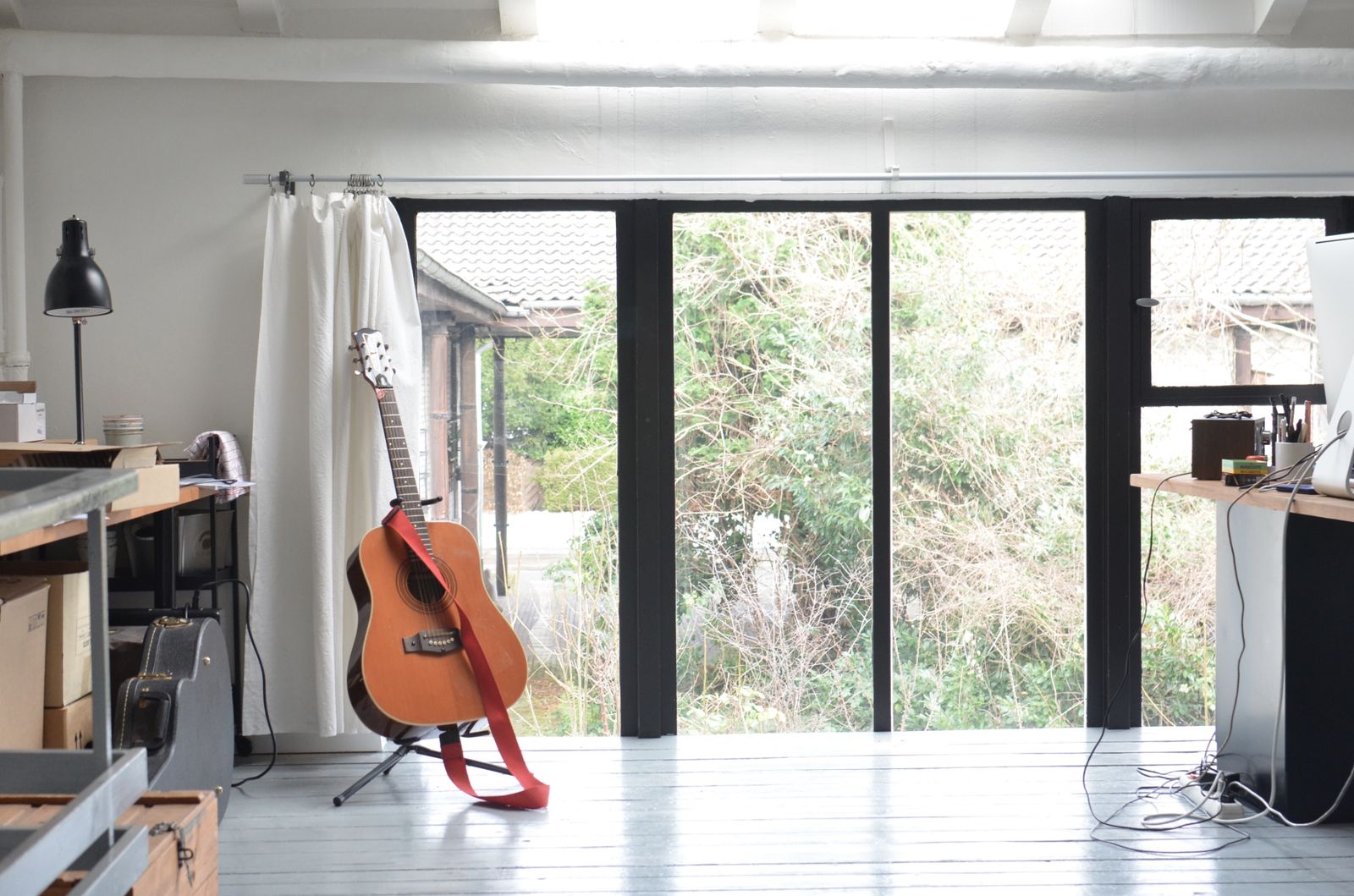 Guitar on a floor stand in a bright room
