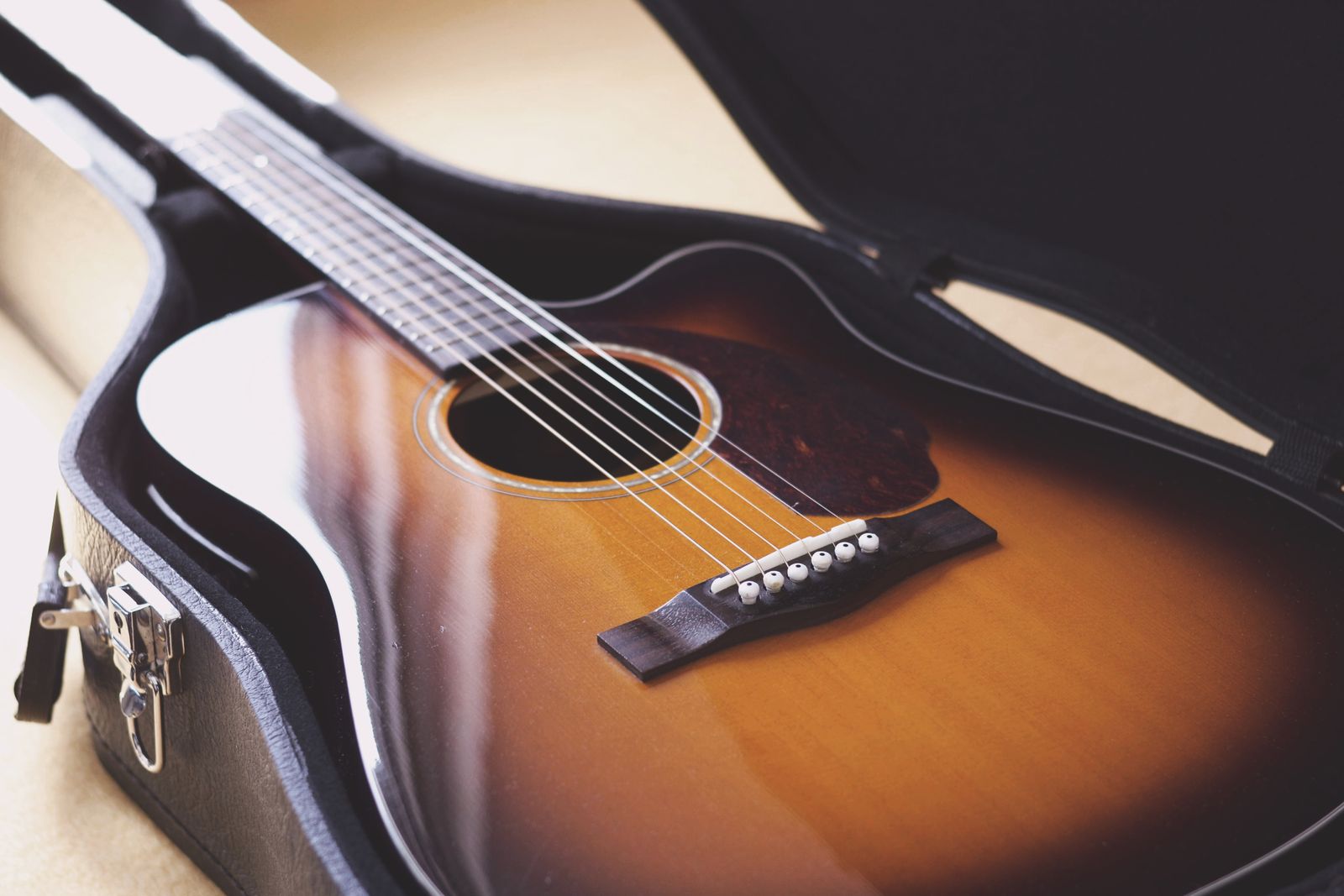 Acoustic guitar resting inside a fitted case