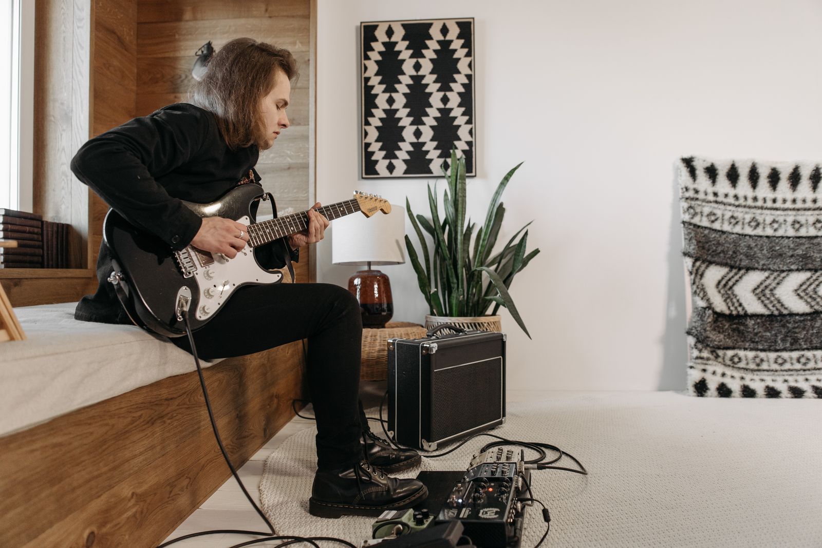 Guitarist practicing beside a small amplifier