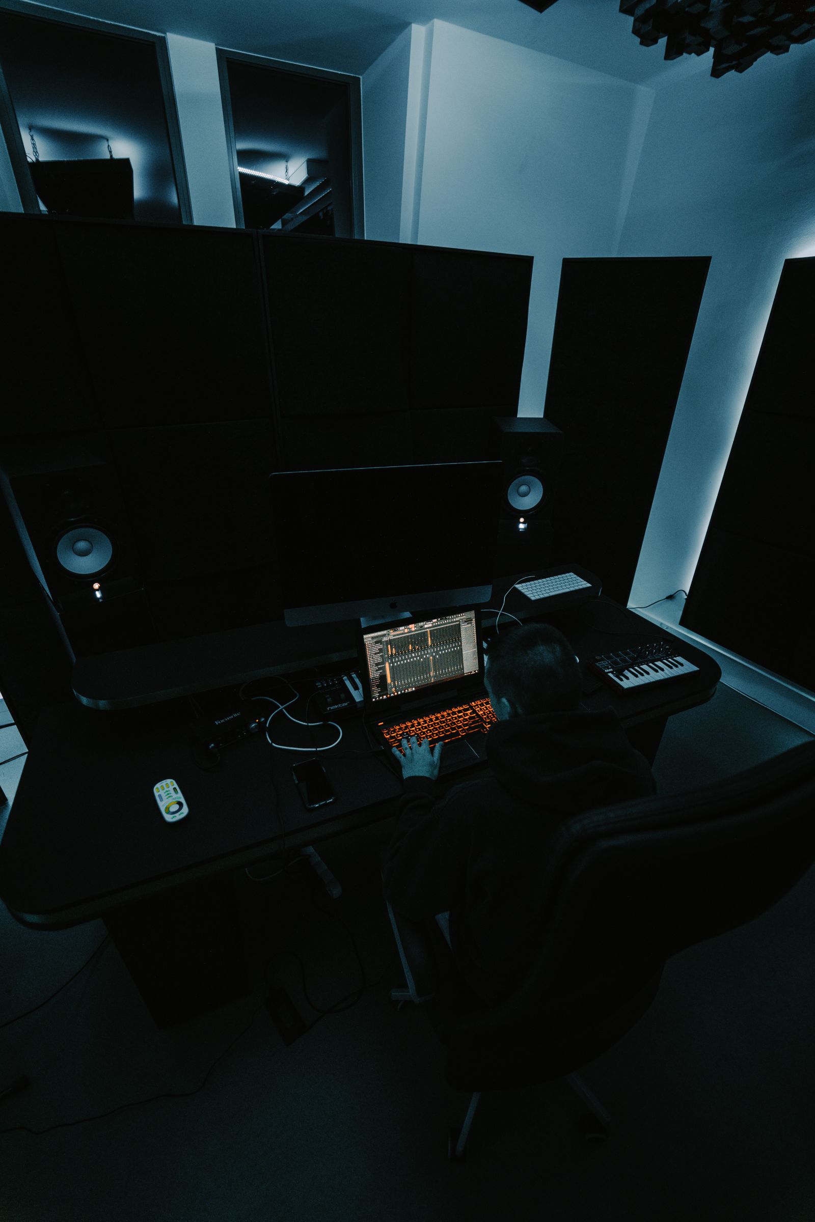 Laptop and music equipment in a dark studio
