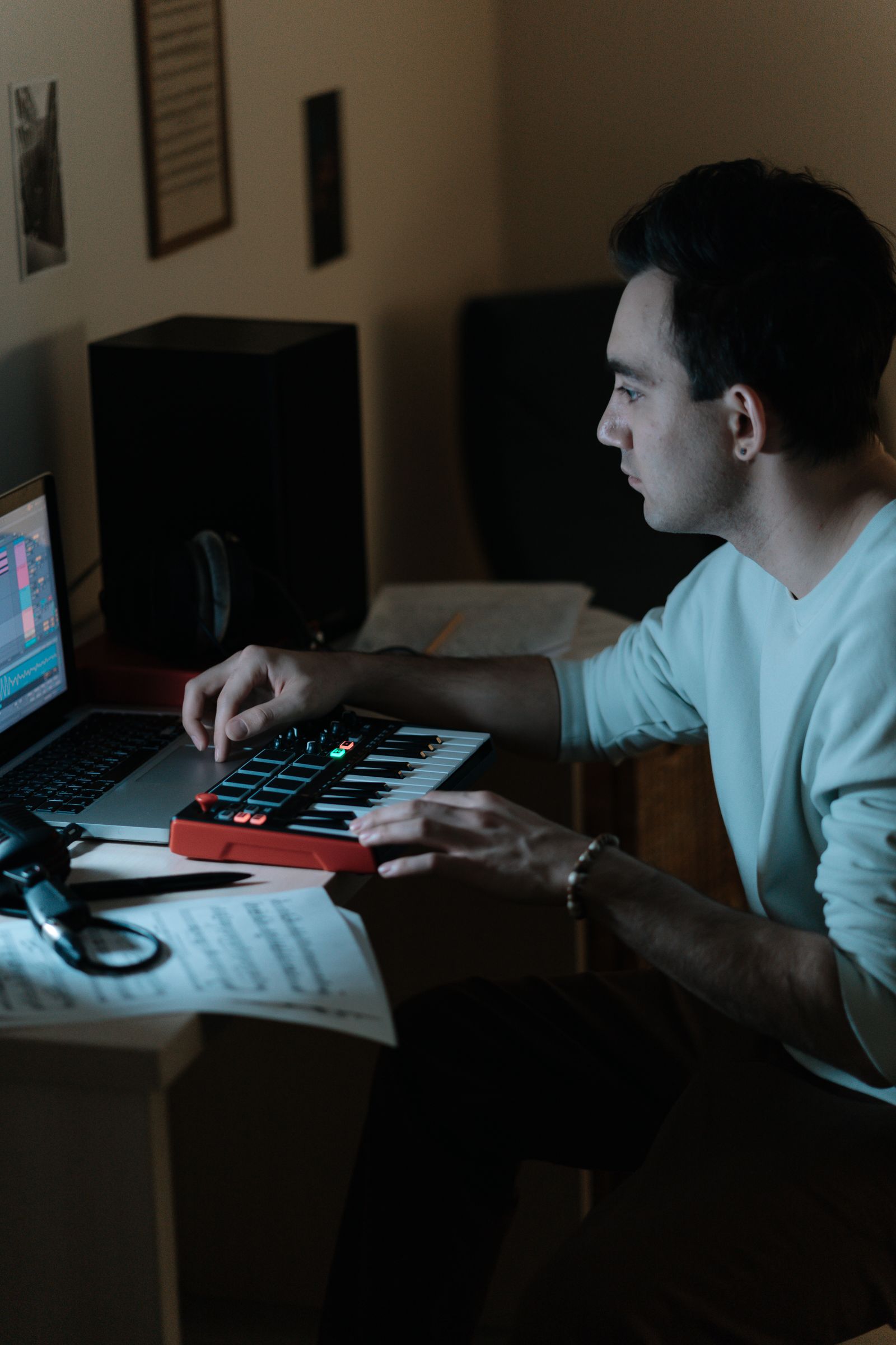 Musician using a compact MIDI controller and laptop