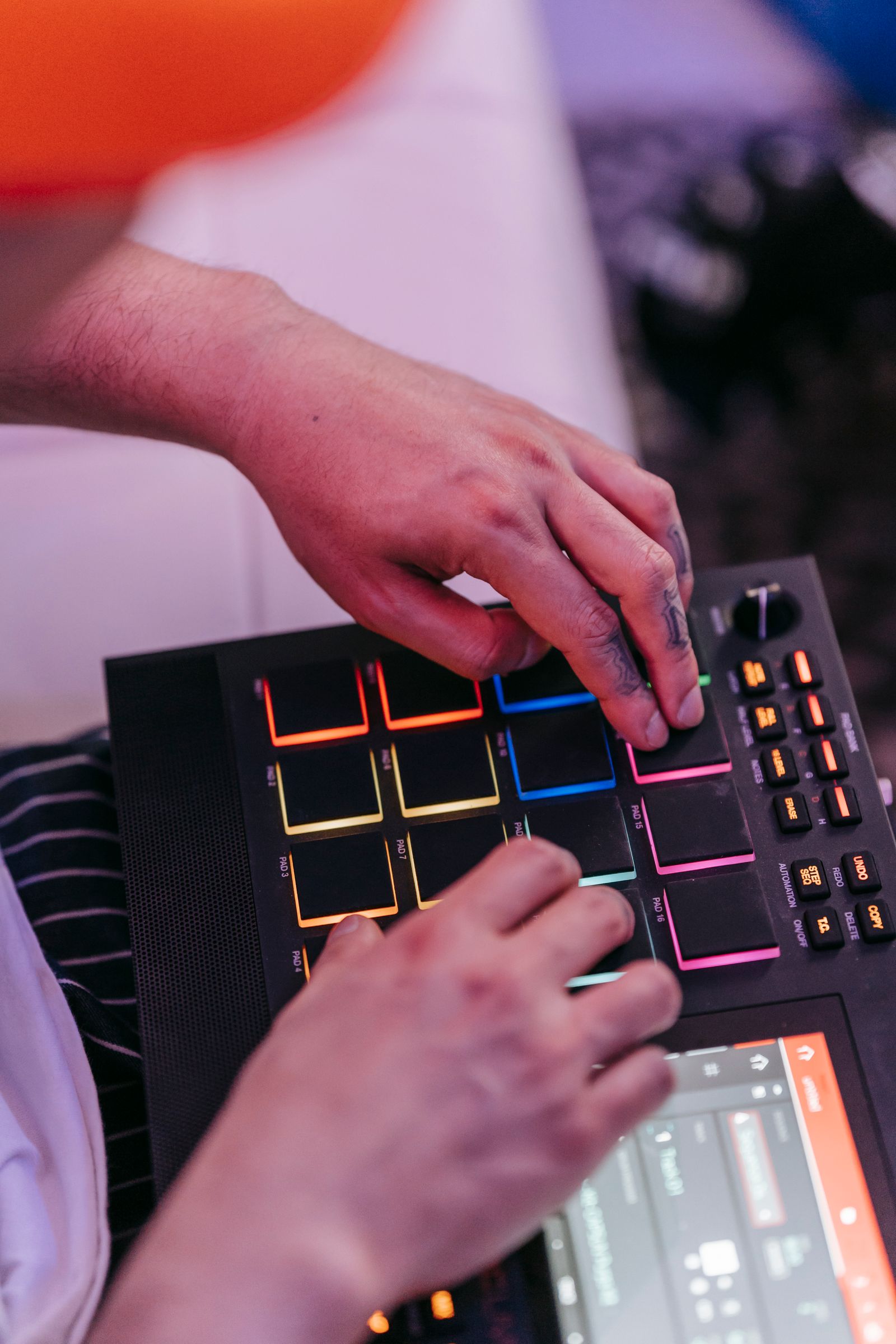 Hands playing illuminated controller pads